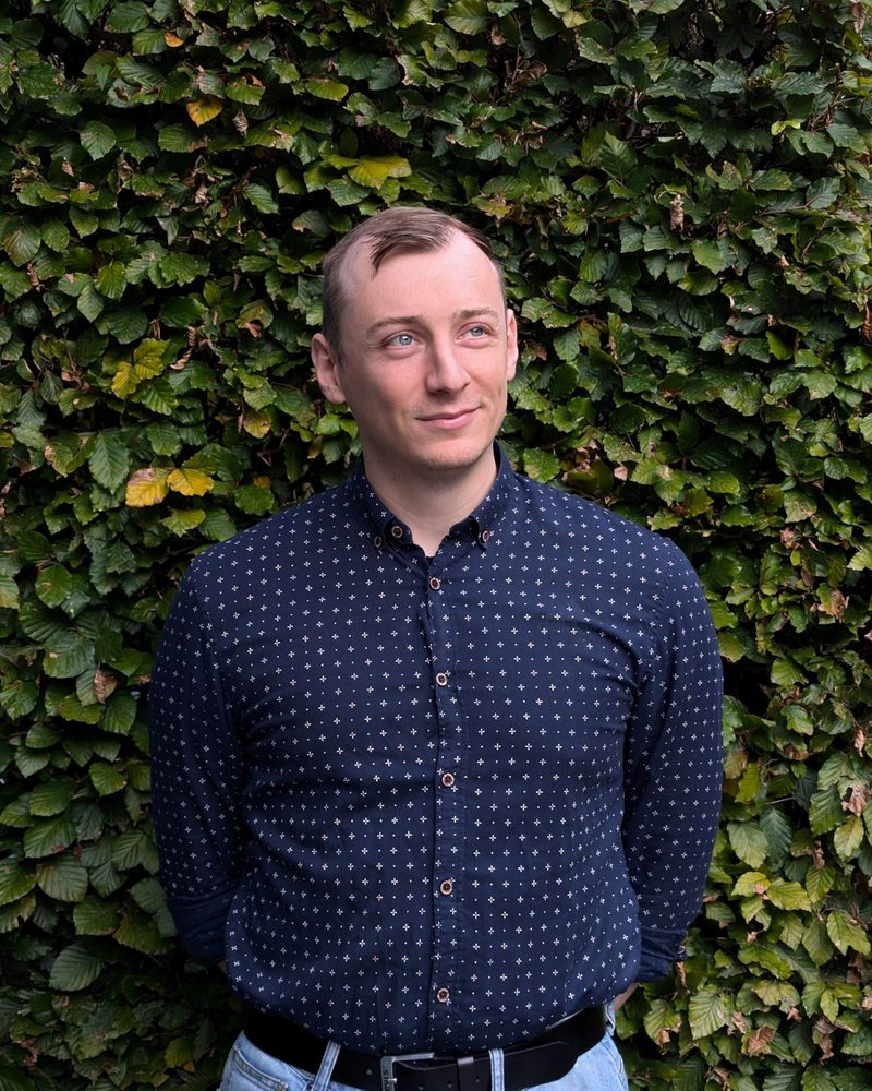 Portret van Jan Van Haeren voor een groene haag
